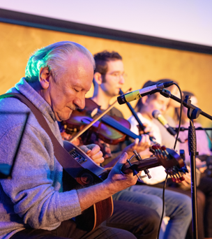 People playing musical instruments on stage.